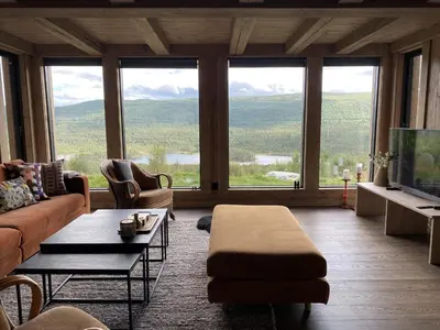 a living room with a couch and a large window at Beautifully styled mountain lodge with high standards, 10 minutes from Geilo in Geilo