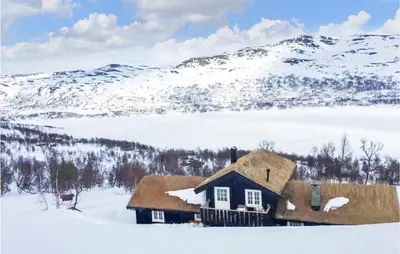 a house in the snow with mountains in the background at 3 Bedroom Nice Home In Oppdal in Oppdal