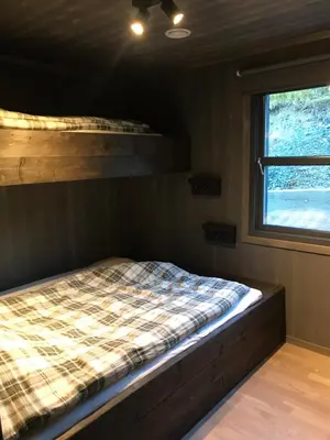 a bed in a room with a window at Vangslia, Oppdal. Lekker leilighet med ski inn/ski ut in Oppdal