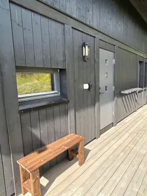 a wooden bench sitting on the side of a building at Vangslia, Oppdal. Lekker leilighet med ski inn/ski ut in Oppdal