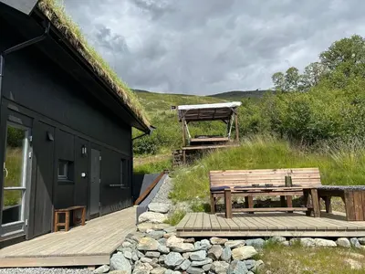 a wooden deck with a bench next to a building at Vangslia, Oppdal. Lekker leilighet med ski inn/ski ut in Oppdal
