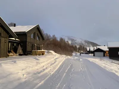a person is walking down a snow covered road at Vangslia, Oppdal. Lekker leilighet med ski inn/ski ut in Oppdal