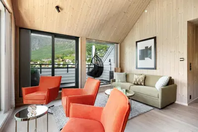 a living room with orange chairs and a couch at Wangen Apartments in Aurland