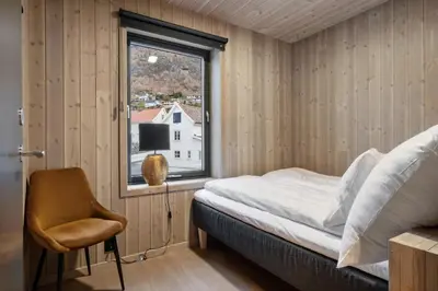 a bedroom with a bed and a window and a chair at Wangen Apartments in Aurland