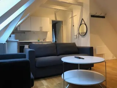a living room with a blue couch and a table at Fløyen Apartment in Bergen