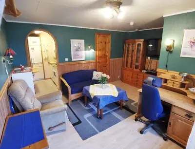 a living room with a couch and a table at Small Basement Apartment Private Entrance Nice View in Fitjar