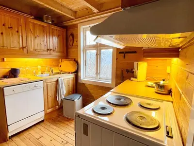 a kitchen with wooden cabinets and a stove top oven at 8 person holiday home in Åkra-By Traum in Åkra