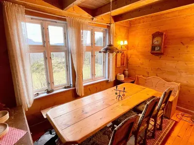 a dining room with a wooden table and windows at 8 person holiday home in Åkra-By Traum in Åkra
