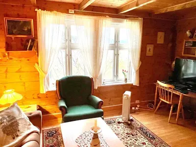 a living room with a green chair and a window at 8 person holiday home in Åkra-By Traum in Åkra
