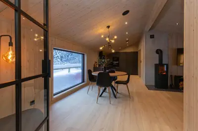 a kitchen and dining room with a table and chairs at High standard cabin close to the Flå city center in Flå