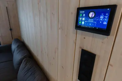 a room with a couch and a tv on a wall at High standard cabin close to the Flå city center in Flå