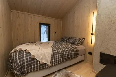a bedroom with a bed in a room with wooden walls at High standard cabin close to the Flå city center in Flå