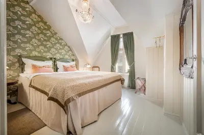 a bedroom with a bed and a chandelier at Jugend 1905 in Ålesund