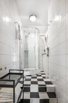 a bathroom with a shower and a black and white checkered floor at Jugend 1905 in Ålesund