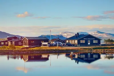 a group of houses next to a body of water at Cozy apartment near Besseggen with a private sauna in Randsverk