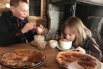 a boy and a girl sitting at a table with food at Cozy apartment near Besseggen with a private sauna in Randsverk