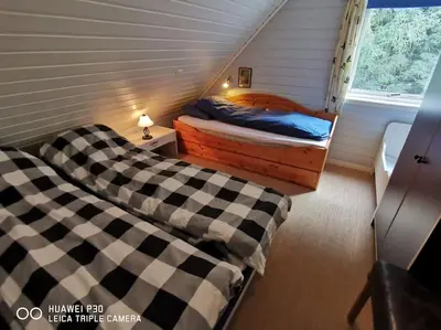 a bedroom with two beds with checkered sheets at Topfloor Apartment Separate Entranc Nice view Stord in Fitjar