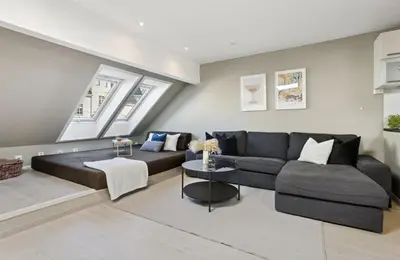 a living room with a couch and a table at Fløyen Lux Apartment in Bergen