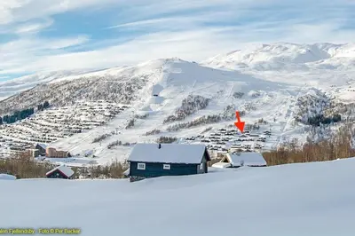 a small house in the snow with a mountain at Large and luxurious family cabin in Myrkdalen in Helgatun