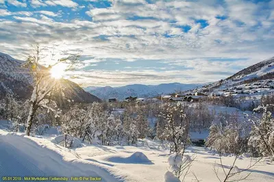 a winter scene with the sun shining through the snow at Large and luxurious family cabin in Myrkdalen in Helgatun