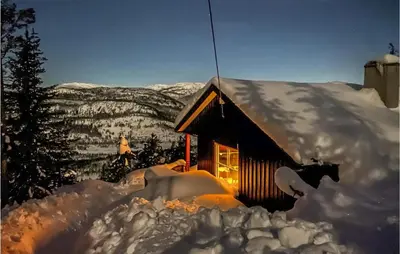 a cabin covered in snow with a mountain in the background at 3 Bedroom Amazing Home In Eggedal in Eggedal