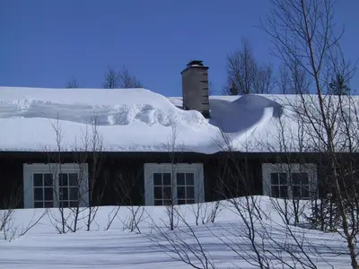 a snow covered roof of a house with a chimney at Gålå Fjellhytter in Gålå