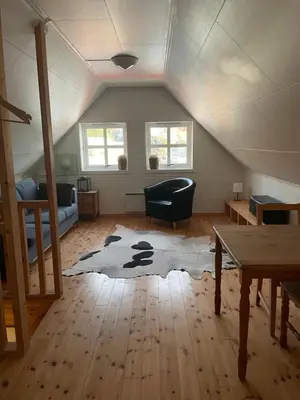 a attic room with a couch and a table at Spacious apartment with view over the trondheimfjord in Vangshylla