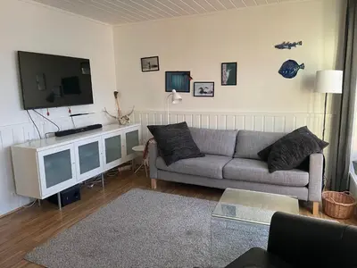 a living room with a couch and a flat screen tv at Spacious apartment with view over the trondheimfjord in Vangshylla