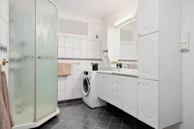 a white bathroom with a sink and a washing machine at Adorable 1-bedroom apartment with a fantastic view - Free Parking in Trondheim