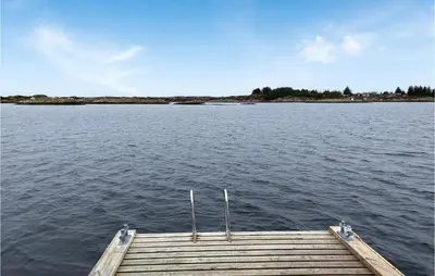 a dock in the middle of a body of water at Beach Front Home In Smøla With Kitchen in Smøla