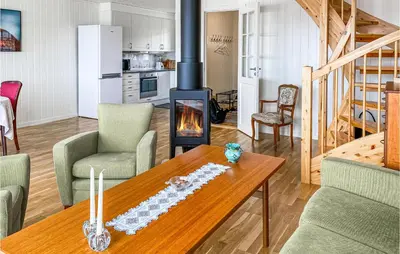 a living room with a table and a fireplace at Beach Front Home In Smøla With Kitchen in Smøla