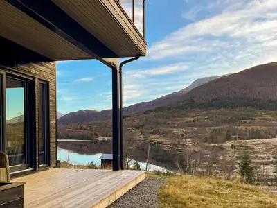 a house with a view of a lake and mountains at Fjellsætra Alpegrend in Sykkylven