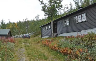 a black house with a car parked next to it at Holiday Home Haugastøl Xxxix in Haugastøl