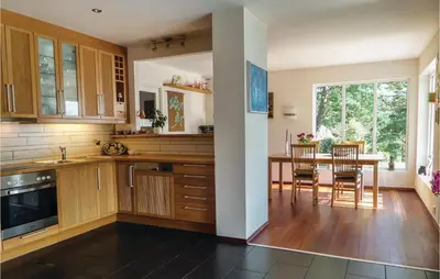 a kitchen with wooden cabinets and a table with chairs at Gorgeous Home In Sveio With Kitchen in Sveio