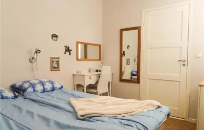 a bedroom with a bed and a mirror and a sink at Gorgeous Home In Sveio With Kitchen in Sveio