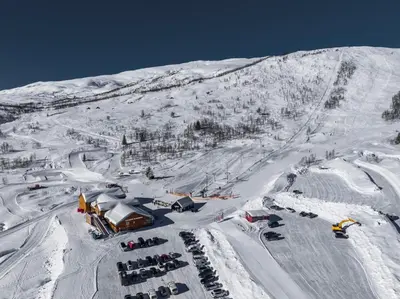 a snow covered mountain with a ski lodge on it at The Panorama Retreat - Rindabotn Cabin in Sogndal