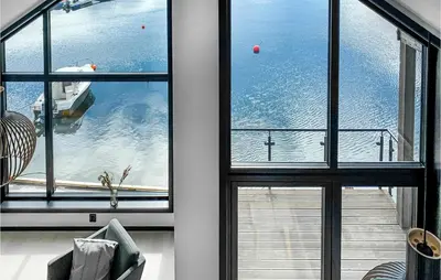 a room with three windows with a view of a boat at 3 Bedroom Awesome Home In Hebnes in Hebnes