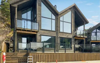 a house with glass windows and a deck at 3 Bedroom Awesome Home In Hebnes in Hebnes