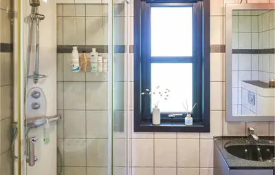 a bathroom with a shower and a sink and a window at Beautiful Home In Hebnes With Kitchen in Hebnes