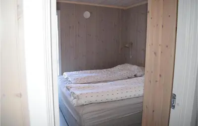 a small bedroom with a bed in a wooden closet at Awesome Home In Rauland With Kitchen in Rauland
