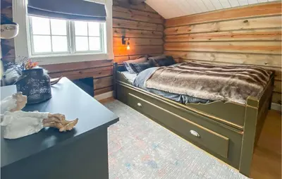 a bedroom with a large bed in a log cabin at Lovely Home In Rauland With Sauna in Rauland