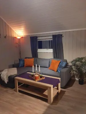 a living room with a couch and a table with candles at Kleines Haus am Fjord in Sør-Eidem