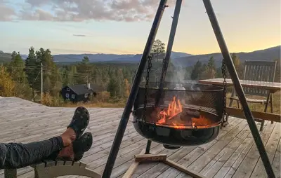 a person sitting on a deck with a fire pit at 3 Bedroom Gorgeous Home In Bykle in Bykle