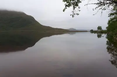 a large body of water with mountains in the background at Strøken leilighet in Åheim