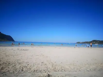 a group of people standing on a beach at Strøken leilighet in Åheim