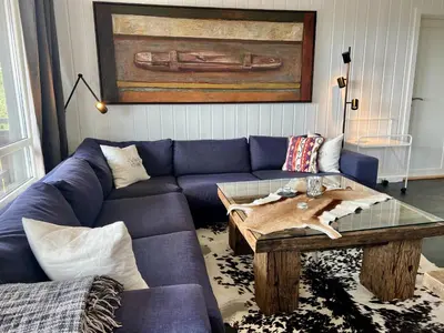 a living room with a blue couch and a table at Bjelbølens stjernely in Beitostøl