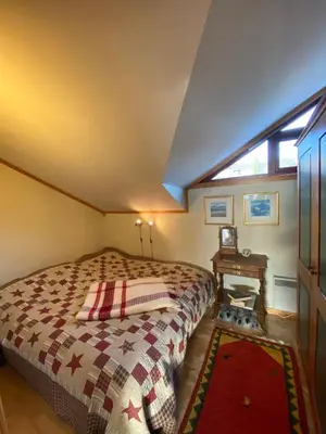 a bedroom with a bed and a table and a window at Apartment City Beitostølen in Beitostøl
