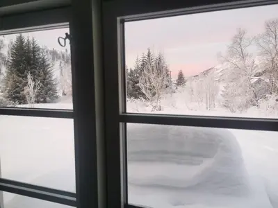 a window with a view of a snow covered yard at Tangen - cabin with 4 bedrooms - great nature in Norheimsund
