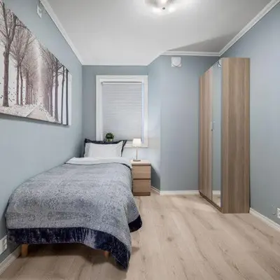 a bedroom with a bed and a painting on the wall at Holmboe Apartment in Bergen