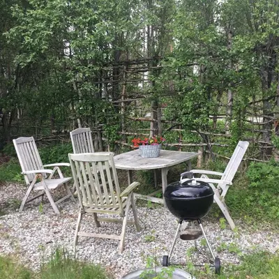 three chairs and a table with a grill and a bbq at Furuly vakantiehuis in Vingelen
